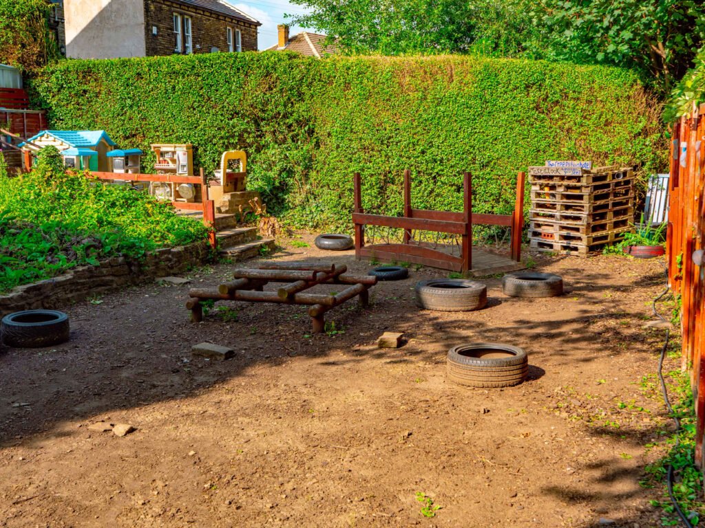 Outdoor loose parts play environment at Hunny Pot Nursery