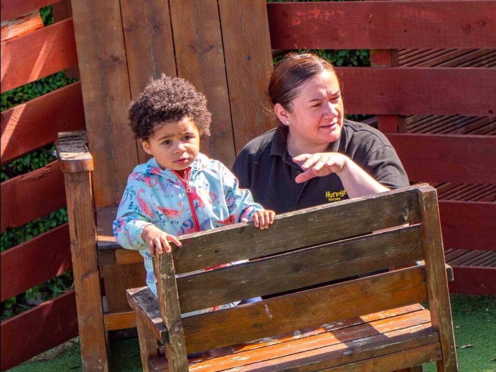 Ofsted-registered Hunny Pot Nursery practitioner engaging with a child outdoors