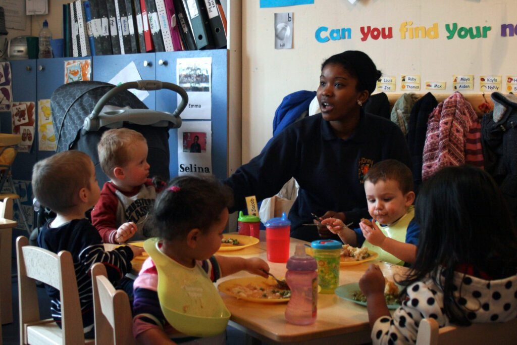 Children sharing a supported mealtime with a nursery practitioner