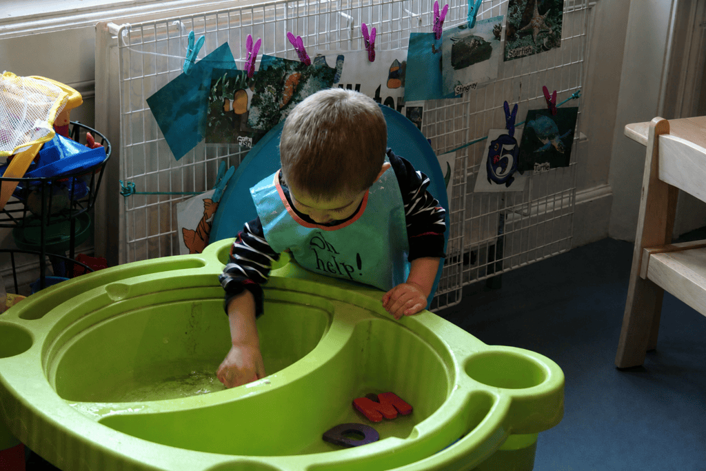 Child investigating water movement and floating objects during water play
