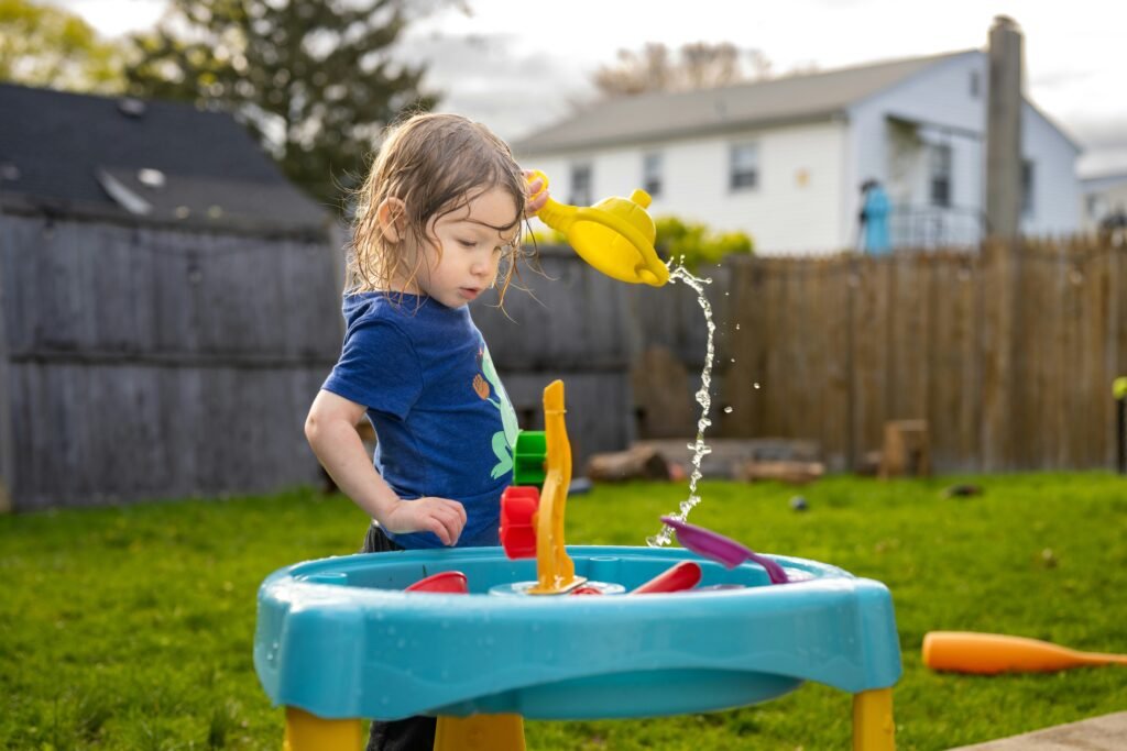 Benefits of outdoor water play as a child explores a water table