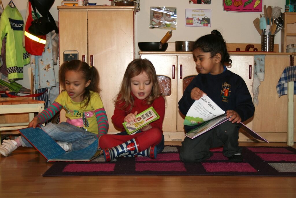 Preschool children sharing books and developing school-readiness skills at Hunny Pot Nursery