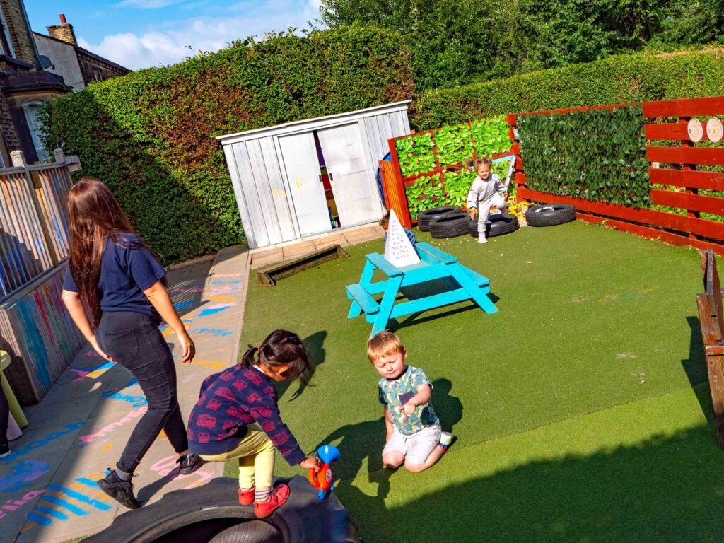 Toddlers developing balance and coordination through outdoor play at Hunny Pot Nursery