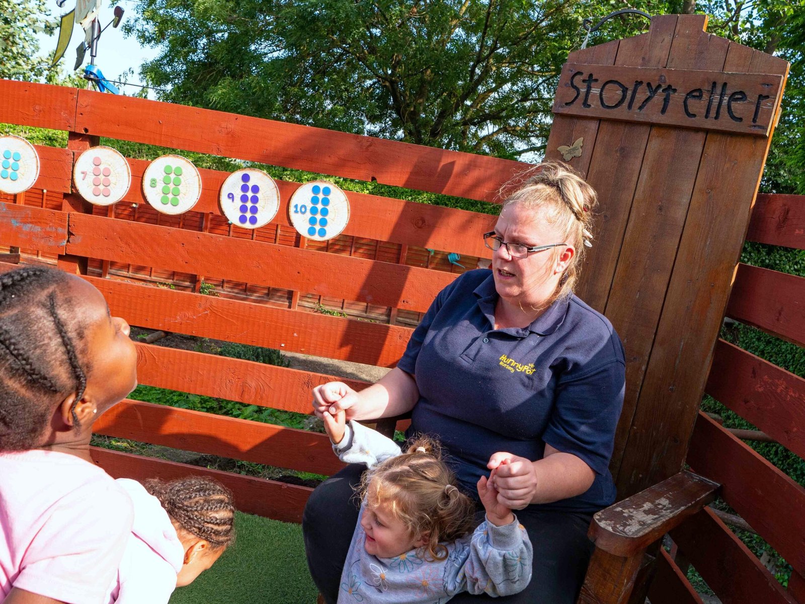 Practitioner supporting children to participate together at Hunny Pot Nursery