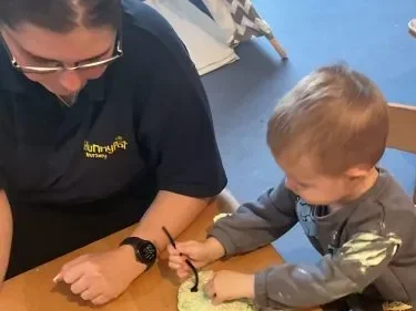Practitioner supporting children during play at Hunny Pot Nursery