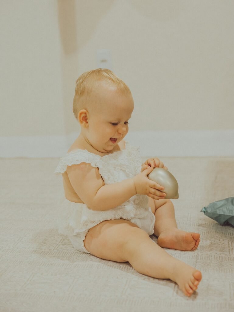 Baby developing sitting, reaching and coordination while playing with a toy
